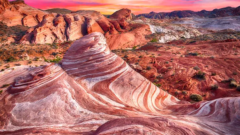 Sunset over the Fire Wave rock formation with its striking red and white striped patterns in Valley of Fire State Park.