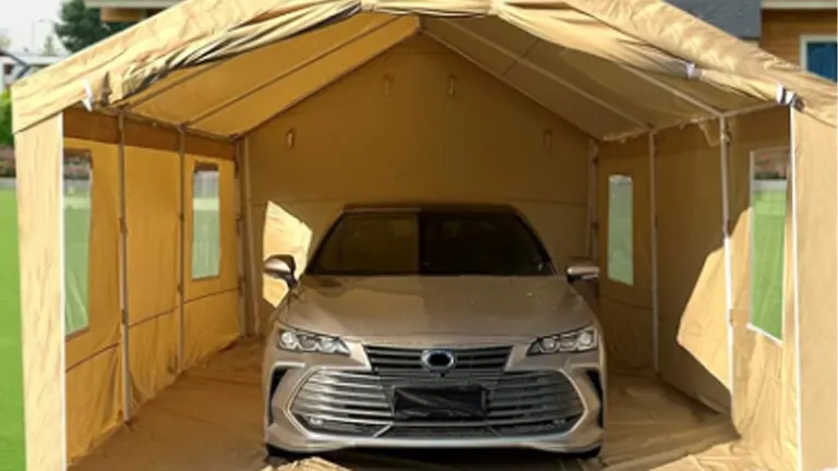 A sedan parked inside a spacious tan portable paint booth, with the front door open, showcasing the booth's interior and size.