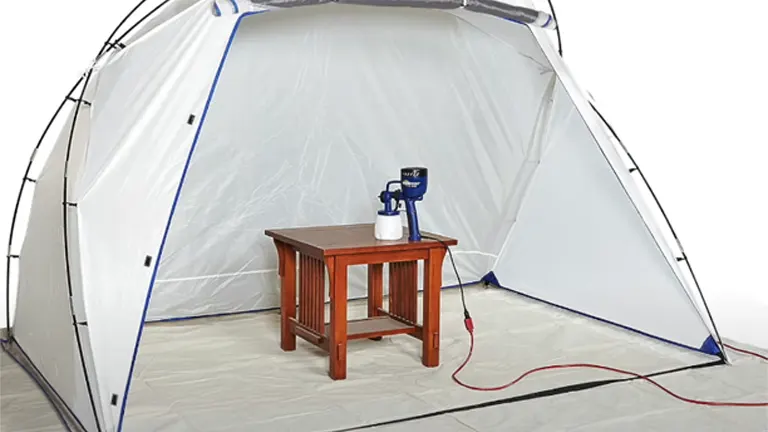 A spray shelter set up with a HomeRight Finish Max paint sprayer on a small table, ready for a painting project.