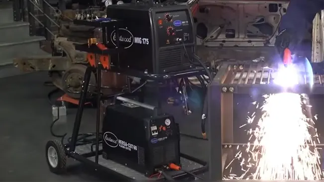 Hot Max WC100 Welding/Plasma Cutter Cart in use with equipment and sparks flying in a workshop.