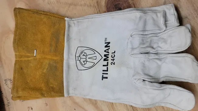 A single Tillman 24C Premium Kidskin TIG welding glove laid out on a wooden surface.