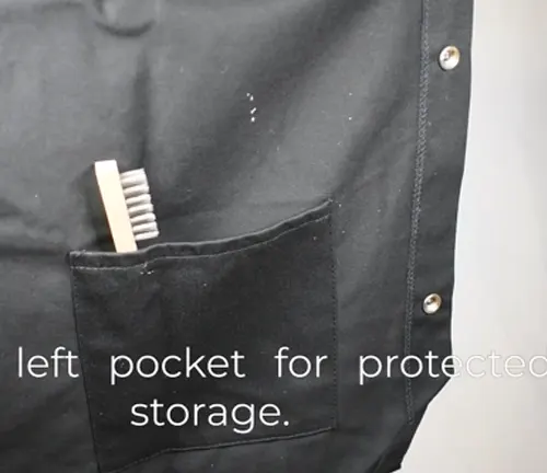 Detail of a Lincoln Electric K2985 welding jacket's black pocket with a welding brush inside, next to text about protected storage.

