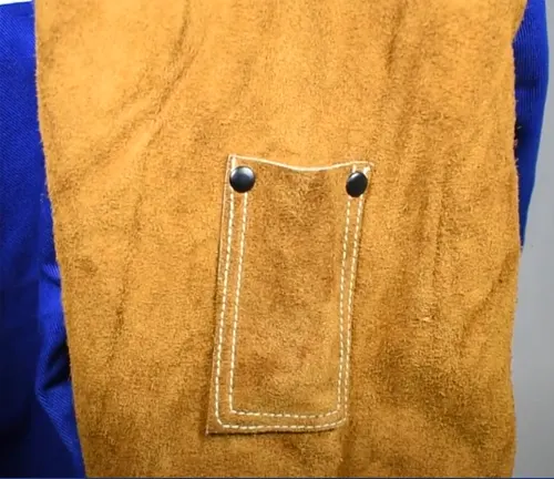 Detail of a cowhide leather pocket on a blue and brown BLACK STALLION Hybrid welding coat with reinforced stitching.