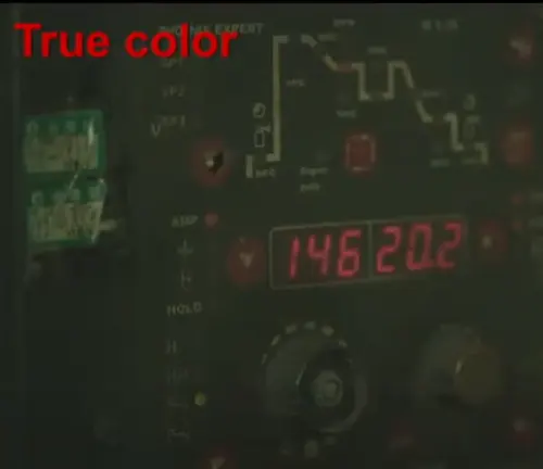Digital welding machine interface with 'True color' text, seen through a welding helmet lens.