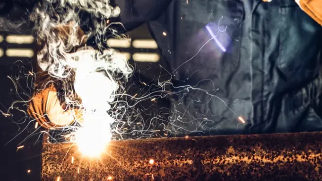 Welding process with bright sparks, featuring Caiman 1878 Welding Gloves in use.