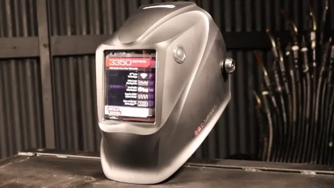 A Lincoln Electric Viking 3350 welding helmet on a workbench, highlighting its large viewing area.