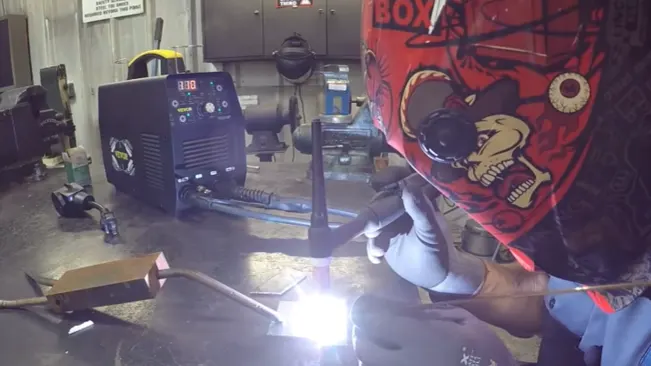 Person welding with a VEVOR TIG Welder 210Amp in a metal workshop.