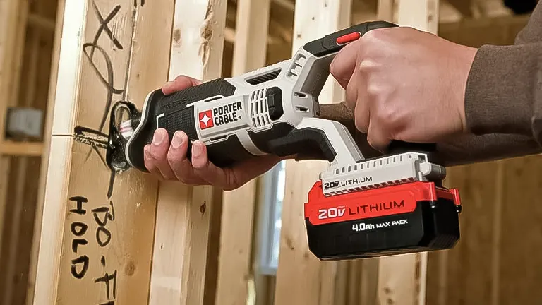 Hand holding a PORTER-CABLE cordless reciprocating saw while cutting wood
