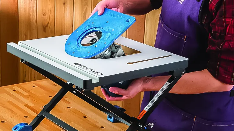 A person adjusting the blue router insert plate on a Rockler benchtop router table, highlighting the tool’s ease of customization