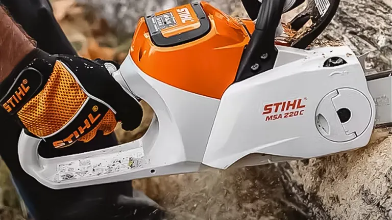 Close-up of a Stihl MSA 220 C chainsaw in use, with focus on its ergonomic handle and branding