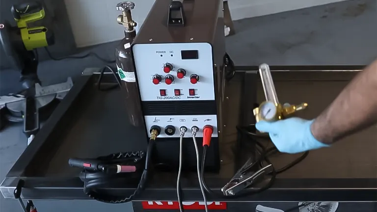 A TIG welder setup with torch and gas bottle, ready for welding