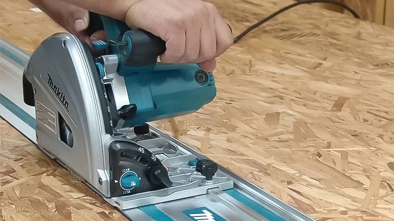 Hand operating a Makita track saw on a guide rail over an OSB panel