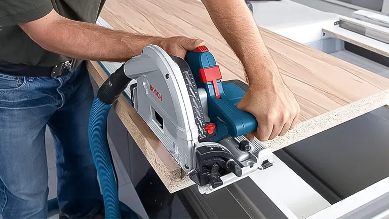Person operating a Bosch track saw on a guide rail, connected to a dust extractor