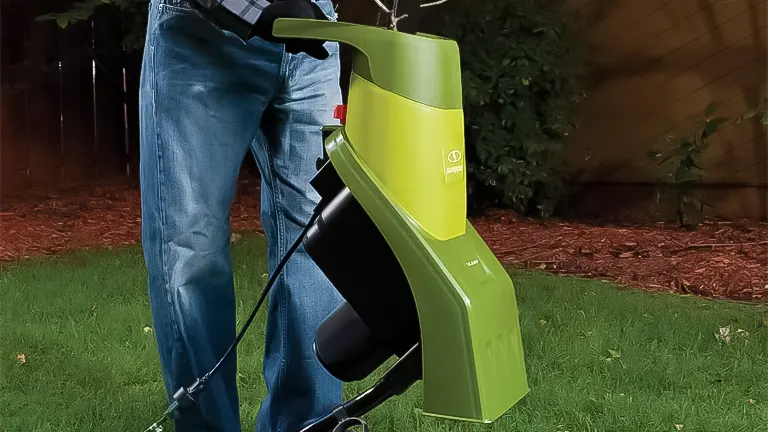 Green and black wood chipper in a garden