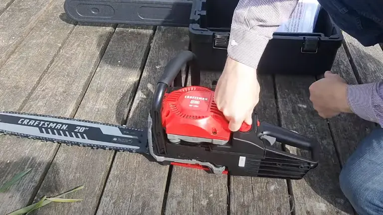 Hands adjusting a CRAFTSMAN 20" gas chainsaw near a toolbox on a wooden deck