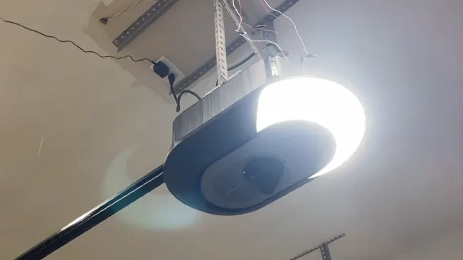 Brightly lit garage door opener system mounted on a garage ceiling