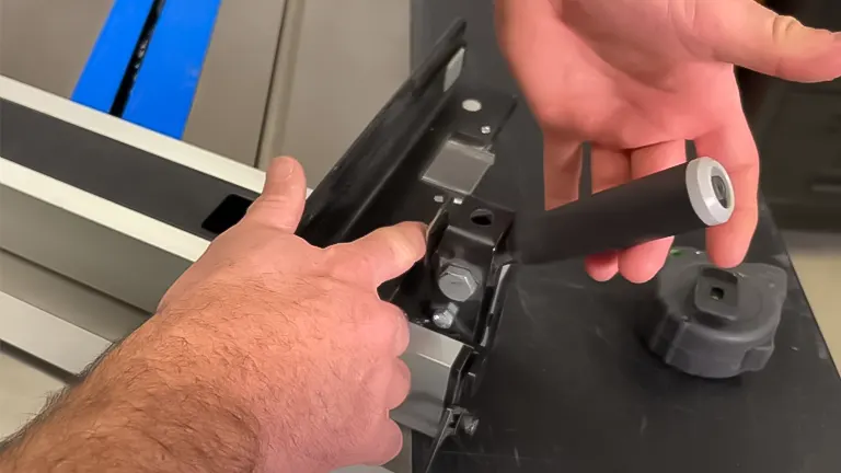 Close-up of hands adjusting the miter gauge on a Delta 36-6013 10 Inch Table Saw