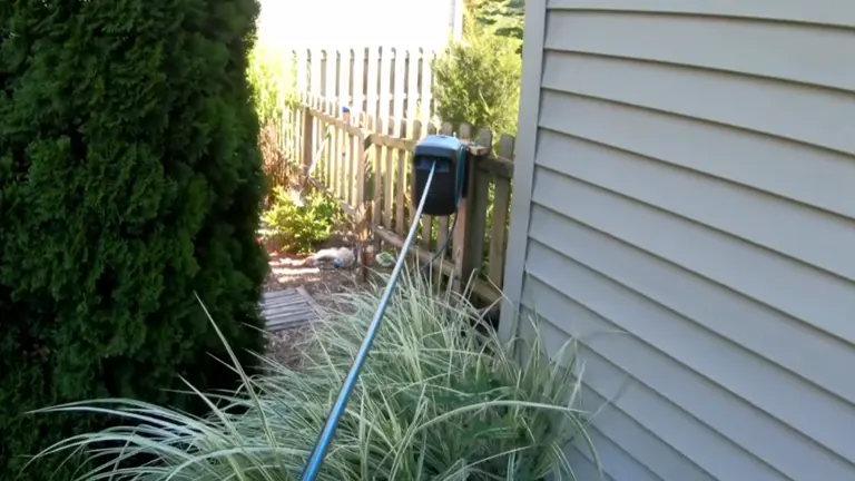 Gardena Hose Reel mounted in the fence pulling the hose