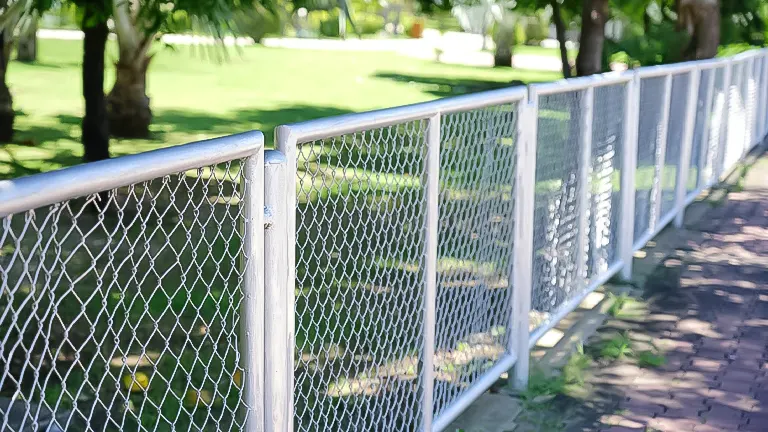 The fence has a diamond-shaped pattern and is made of metal