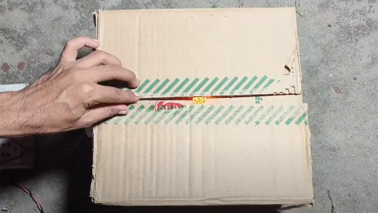 Person closing a homemade egg incubator made from a cardboard box