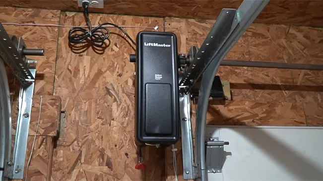 Wall-mounted LiftMaster garage door opener with jackshaft mechanism, part of a track system in a garage with wooden walls.