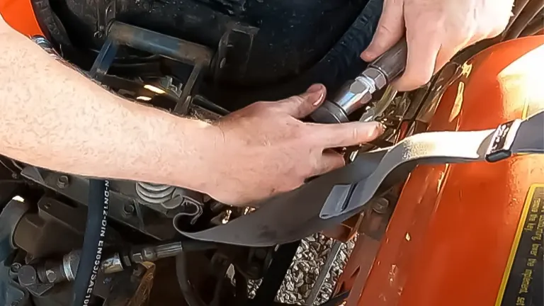 Hands working on tractor linkage adjustment