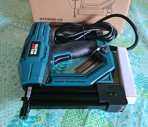 NEU MASTER electric nail and staple gun on patterned background with box and power cord.