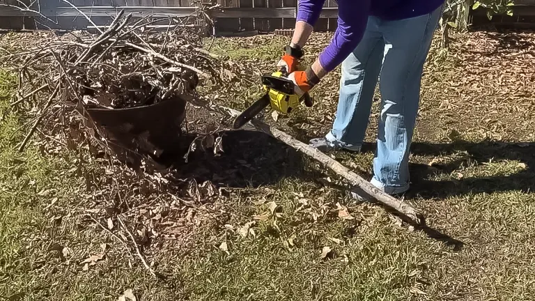 Person using a yellow QZTODO 25.4CC gas-powered chainsaw to cut through a log on a sunny day