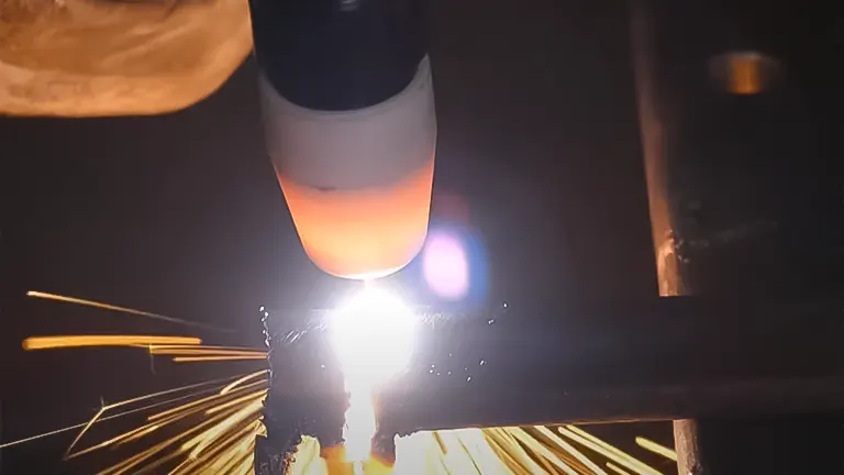 Welding in progress with a bright arc and sparks, showcasing a welder's torch in use