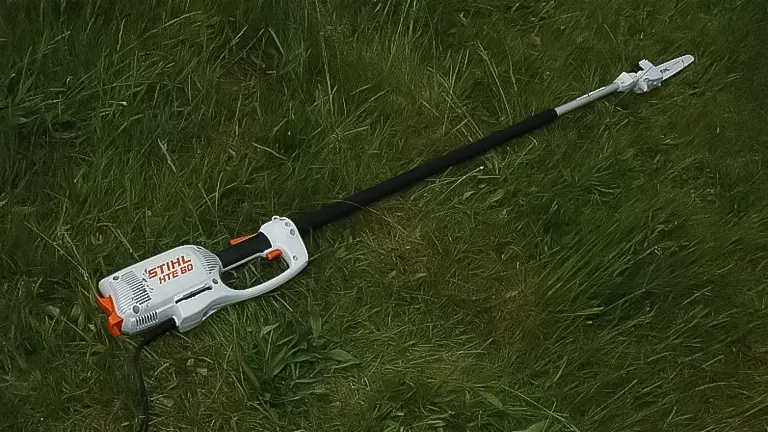 Stihl HTE 60 electric pole saw lying on grass