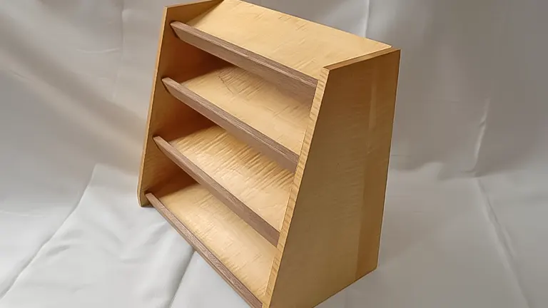 A light-colored wooden three-shelf bookcase against a plain white backdrop