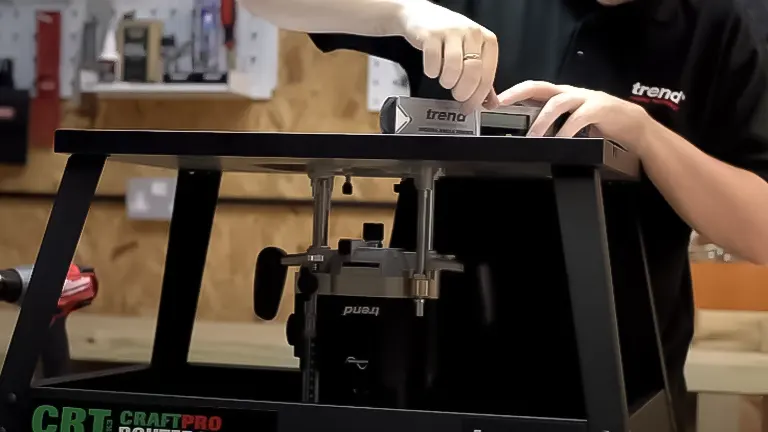 Person adjusting a router on the Trend CRT/MK3 Craft Pro Benchtop Router Table