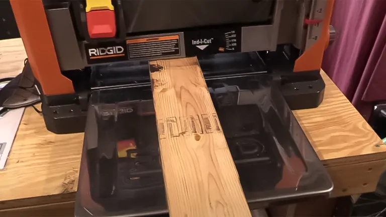 Smooth wooden plank on a black benchtop jointer in a workshop