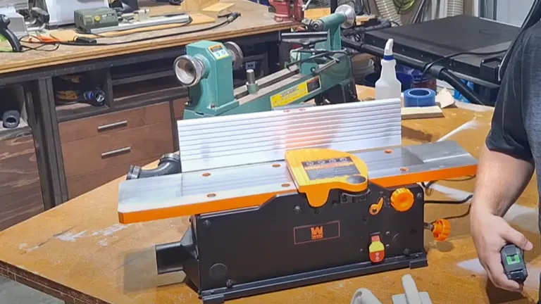 WEN JT3062 jointer on a workbench with woodworker holding a measuring device