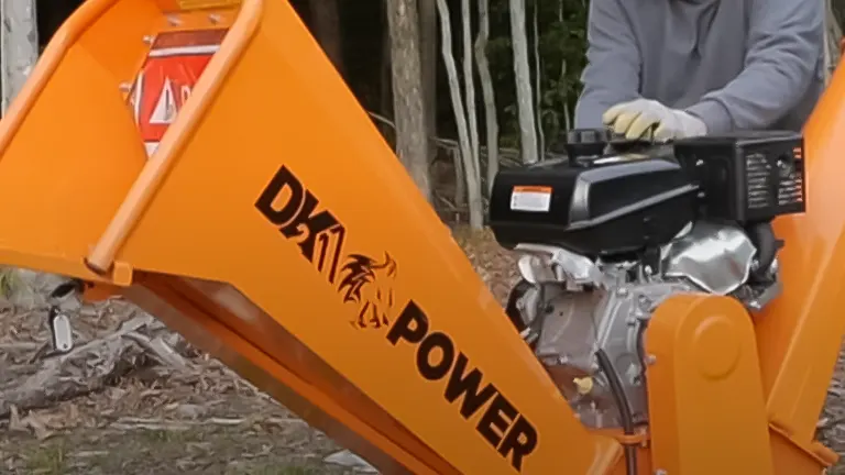 Close-up view of the orange DK2 Power wood chipper with engine details and operator