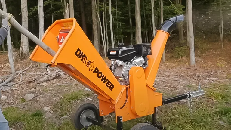 DK2 Power wood chipper with visible gas engine and electric start, set in a forested area with someone feeding in branches