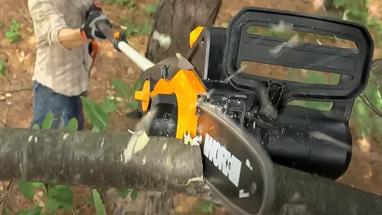 Person using a Worx WG309 electric pole saw to cut through a thick branch