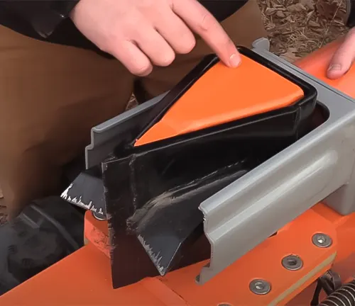 Hand pointing at the wedge of a YARDMAX XR1450 40-Ton Gas Log Splitter during operation
