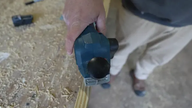 Person using bosch planer wood with power tool