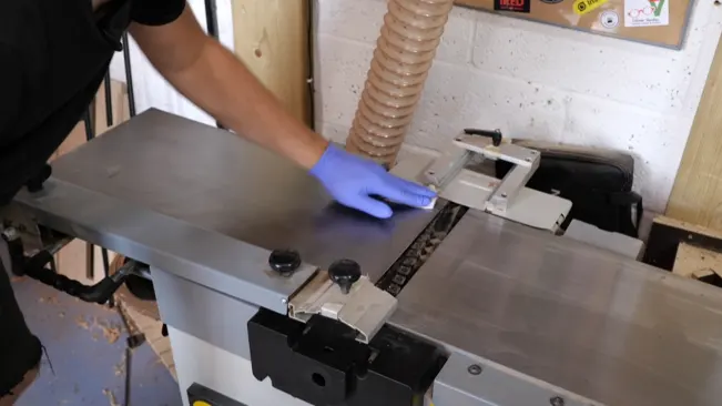Person cleaning a woodworking machine