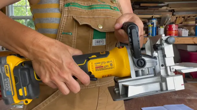 Person using a power tool in a woodworking workshop