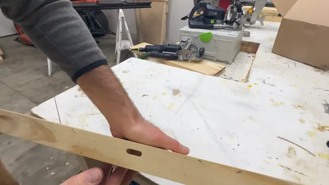 Person holding wooden plank in a workshop