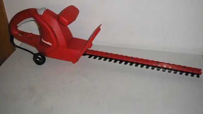 Red Homelite electric hedge trimmer on white background