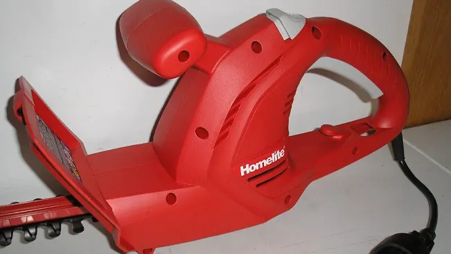 Red hedge trimmer on table
