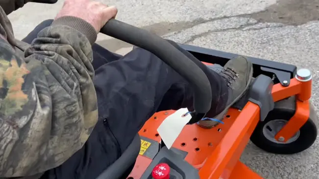 person operating a lawn riding lawn mower