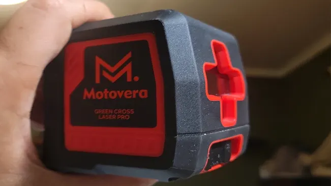 Hand holding a Motovera Green Cross Laser Pro