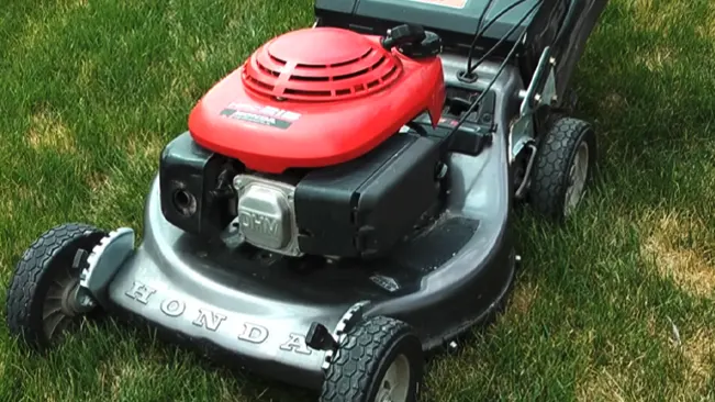 A red Honda lawn mower on a green lawn
