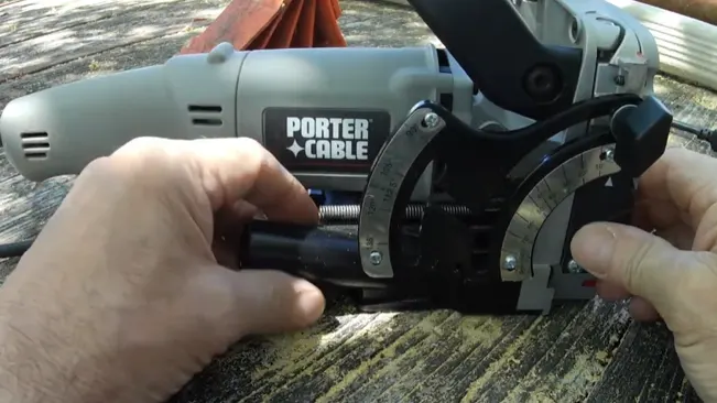 Person fine-tuning a PORTER-CABLE power tool on a wooden surface