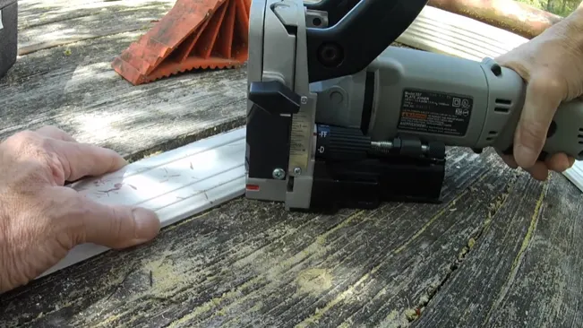 Person safely using a power tool to cut wood.