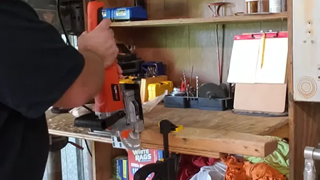 Person using a power tool in a well-stocked woodworking workshop